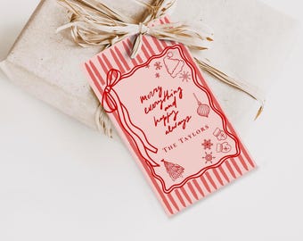 Peut inclure: Une étiquette cadeau rectangulaire avec un fond rose clair et des bordures rayées rouges. L'étiquette présente des dessins au trait rouges représentant un bonnet de Père Noël, des flocons, un sapin et des moufles. Elle porte le texte "merry everything and happy always" et "THE TAYLORS".