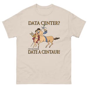 May include: A beige short-sleeve t-shirt featuring a graphic illustration of a centaur and a person playing a lyre. The text above reads DATA CENTER? and the text below reads I'D RATHER DATE A CENTAUR! in a classic serif font style.