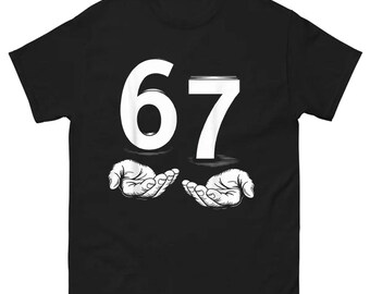 May include: Black t-shirt with the number "67" in white, above a graphic of two open hands. The hands are cupped, as if holding something. The design is centered on the shirt.
