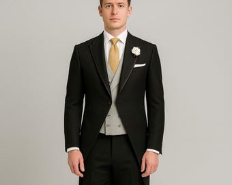 Peut inclure: Un costume noir formel avec une veste longue, associé à un pantalon noir et des chaussures en cuir noires. Le costume comprend un gilet gris, une chemise blanche et une cravate dorée. Une fleur blanche orne la boutonnière.