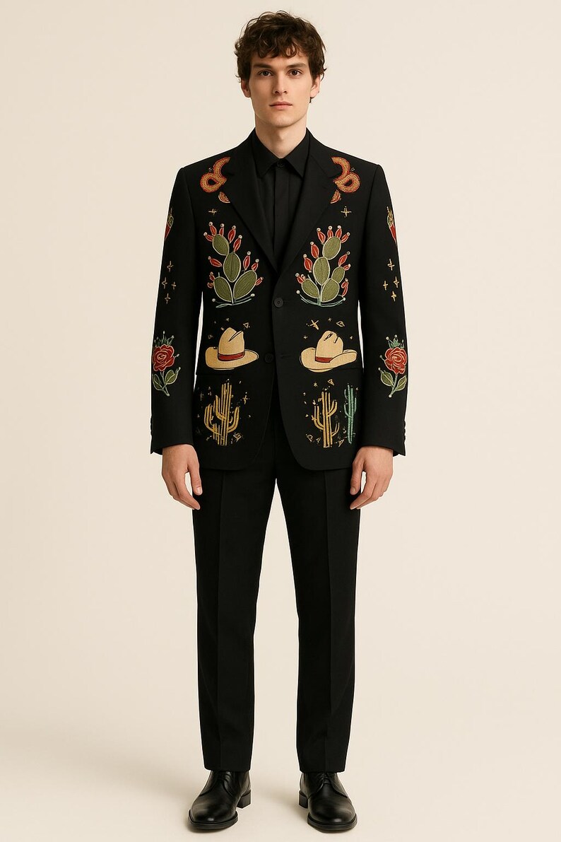 May include: Black suit with embroidered desert-themed designs. The blazer features cacti, cowboy hats, and roses in green, red, and yellow. The suit is paired with a black dress shirt and black dress pants.