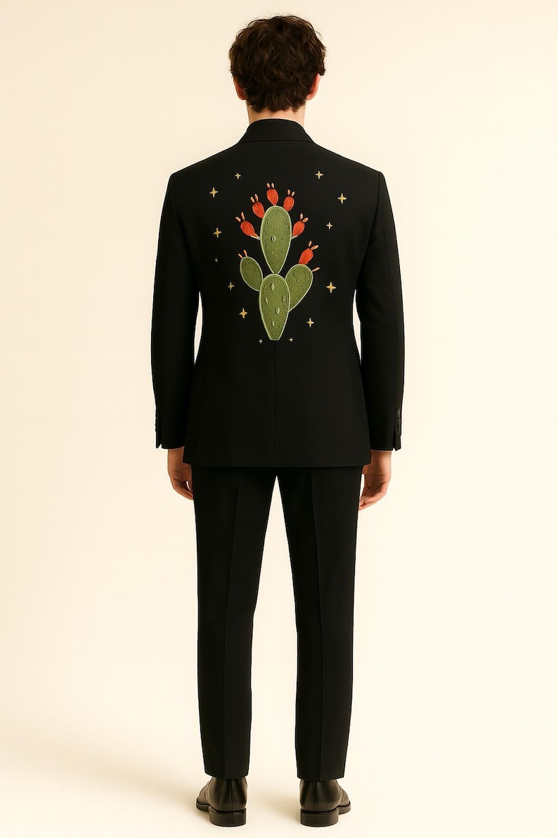 May include: Black suit with an embroidered cactus design on the back. The cactus is green with red accents, surrounded by small gold stars. The suit includes a matching black jacket and pants.
