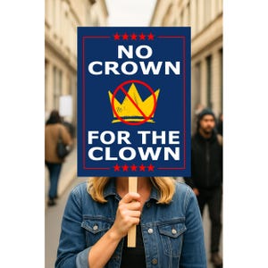 May include: A person holding a sign with the text "NO CROWN FOR THE CLOWN". The sign is blue with white text and a yellow crown with a red slash through it. The sign is framed in red and has red stars at the top and bottom.