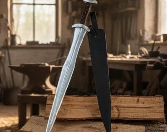 May include: A silver sword with a brown leather-wrapped handle and a black sheath. The sword is displayed on a stack of wooden logs, with a blurred workshop background.