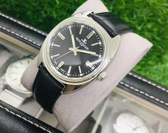 Reloj de pulsera Jaeger-LeCoultre Club vintage: esfera negra, cuerda manual, correa de piel negra.