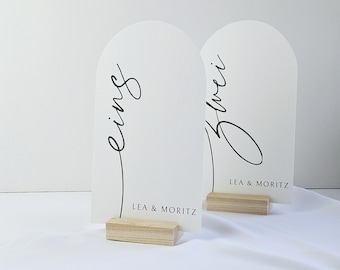 Elegantes números de mesa para bodas y confirmaciones, modernas tarjetas de lugar minimalistas con forma de arco, letras a mano de estilo bohemio.