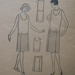 May include: A vintage sewing pattern for a sleeveless dress with a skirt that can be made with either a solid fabric or a plaid fabric. The pattern includes instructions for making the dress and a separate skirt.