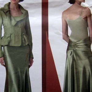May include: A two-piece olive green formal outfit. The jacket has a unique collar and button closure, paired with a matching skirt. The skirt has a slight flare at the bottom. The second image shows a matching olive green camisole and skirt.