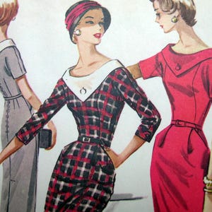 May include: A vintage fashion illustration featuring three dresses: a grey dress with a white collar, a black and red plaid dress with a white V-neck collar and belt, and a solid red dress with a wide collar, short sleeves, and a thin waist belt.