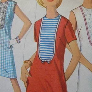 May include: Three sleeveless dresses, one with a blue and white gingham pattern, one with a red bodice and a blue and white striped bib, and one with a white bodice and a pink and white floral pattern.