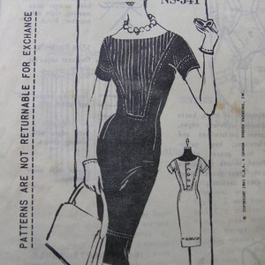 May include: A vintage sewing pattern illustration of a fitted dress with vertical lines on the bodice and short sleeves. The illustration is in black and white, with a small dress form sketch. The text "PATTERNS ARE NOT RETURNABLE FOR EXCHANGE" is visible.