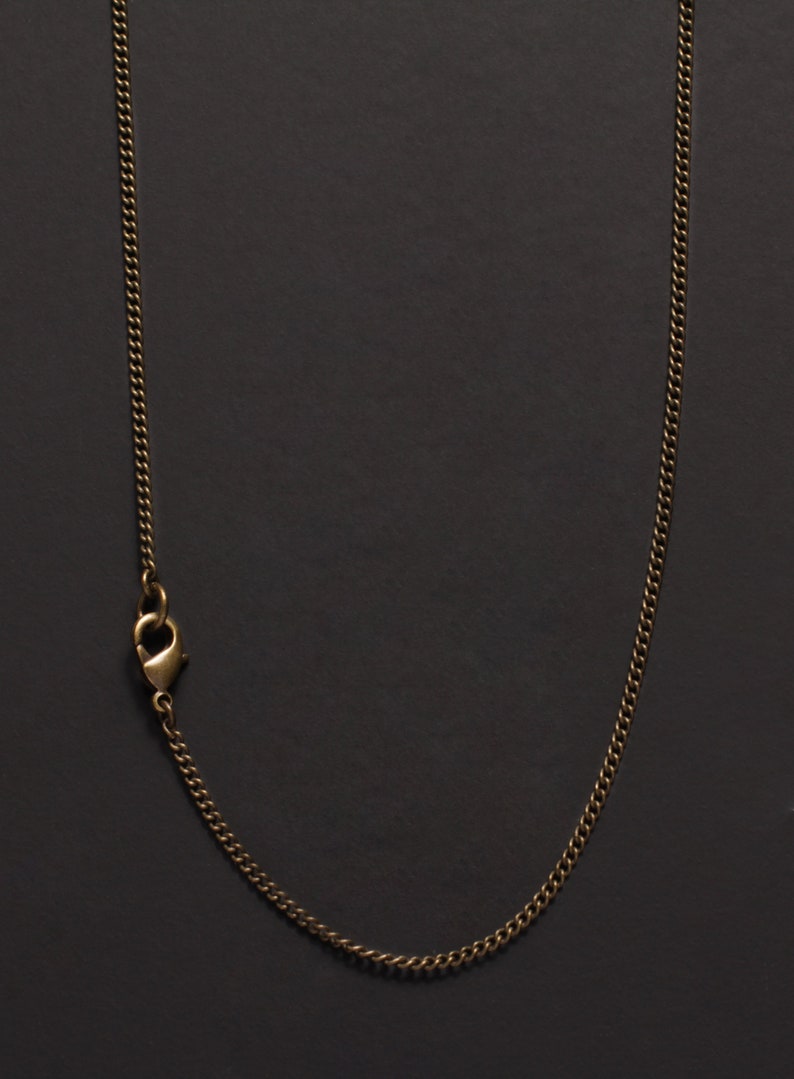May include: A gold chain necklace with a lobster clasp closure.