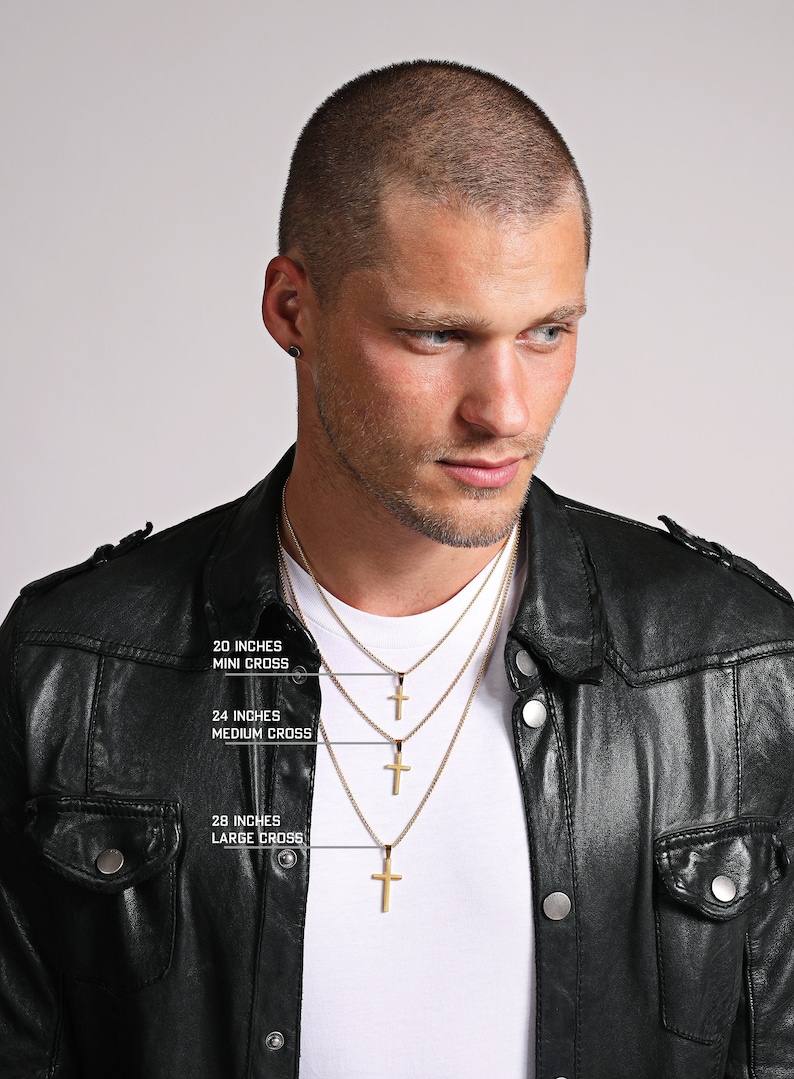 May include: A man wearing a black leather jacket is wearing three gold chains with different sized crosses. The chains are labeled with their lengths: 20 inches, 24 inches, and 28 inches. The crosses are labeled as mini, medium, and large.