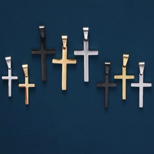 May include: A collection of eight silver, gold, and black cross pendants. The crosses are all different sizes and styles, but they are all made of metal.