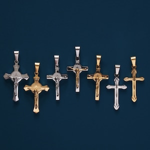 May include: Seven silver and gold cross pendants with a religious figure on each. The crosses are on a blue background.