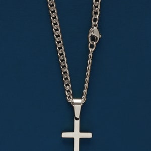 May include: A silver chain necklace with a silver cross pendant.