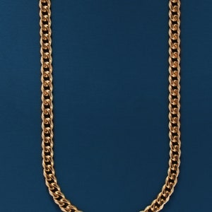 May include: A gold chain necklace on a blue background.