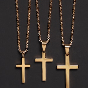 May include: Three gold chain necklaces with different sized cross pendants. The chains are all the same style, with a box chain design.
