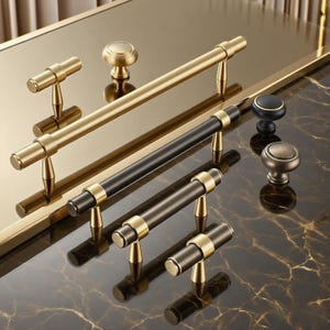 Peut inclure: Divers poignées et boutons de meubles dorés et noirs. L'assortiment comprend des boutons et des barres de tirage de différentes formes et tailles, avec des finitions dorées et noires. Les articles sont présentés sur une surface réfléchissante.