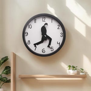 May include: A black and white wall clock with a unique design. The clock face is white with black numbers and hands. A black silhouette of a man walking is integrated into the clock's design, adding a playful touch. The clock is mounted on a beige wall.