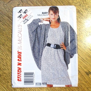 Peut inclure: Un patron de couture McCall's vintage avec une femme portant une robe et une cape. Le patron est étiqueté "STITCH 'N SAVE" et comprend des informations de taille et de prix. La robe et la cape ont un motif à pois noir et blanc.