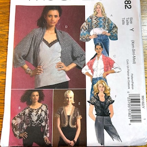 May include: A sewing pattern with illustrations of women's tops and jackets. Designs include a patterned kimono, a chevron-patterned top, a pink bolero, and a black lace top. The pattern size is Y (Xsm-Sml-Med).