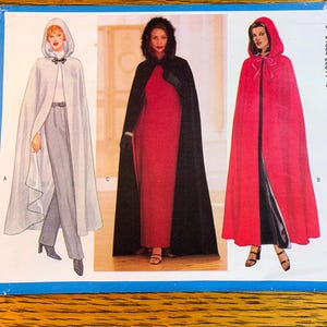 May include: A sewing pattern showing three hooded capes. The capes are displayed in white, black with a fur-trimmed hood, and red. Each cape has a different fastening detail. The pattern includes illustrations of the capes and their design.