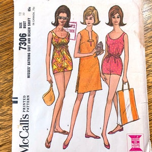 May include: Vintage McCall's sewing pattern for a bathing suit and beach shift. The pattern is for sizes 12 and 32 bust. The pattern is printed on white paper with a black and white illustration of three women wearing the different styles. The pattern number is 7306.