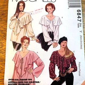 May include: A vintage sewing pattern with illustrations of four blouses, each with a different design. The blouses have ruffled details, long sleeves, and V-necklines. The pattern includes the size Y (Xsm, Sml, Med). The text "OVERLOCK/SERGER TIPS" is visible.