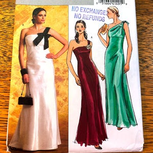 May include: A sewing pattern with illustrations of three elegant gowns. The dresses include a white one-shoulder gown with a black bow, a burgundy one-shoulder dress, and a green one-shoulder dress. The text "NO EXCHANGE NO REFUNDS" is visible.