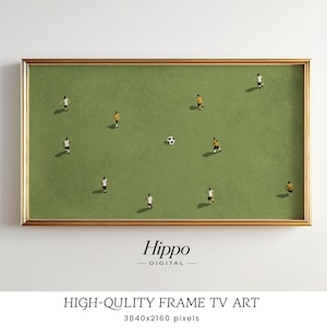 May include: A framed art print featuring a soccer game scene. The artwork depicts a green field with miniature figures in white and yellow uniforms, a soccer ball, and a gold frame. The text "Hippo Digital" is at the bottom.