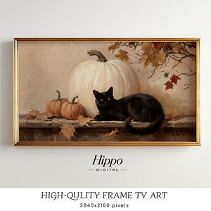 以下が含まれることがあります： ゴールドのフレームに入ったデジタル絵画。大きな白いカボチャ、2つの小さなオレンジ色のカボチャ、棚の上で休む黒猫が描かれています。周囲には乾燥した秋の葉が散らばり、上部には枝があります。テキストは「Hippo DIGITAL」と書かれています。