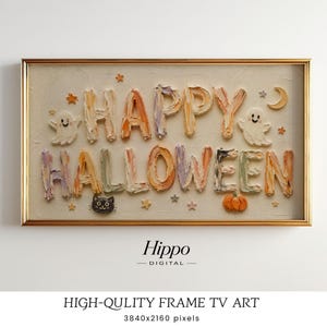 Op de afbeelding: Een rechthoekig ingelijst digitaal kunstwerk met de tekst HAPPY HALLOWEEN in een dikke, getextureerde impasto-stijl. Het ontwerp bevat kleine illustraties van twee geesten, een zwarte kat, een pompoen, sterren en een halve maan op een crèmekleurige achtergrond.