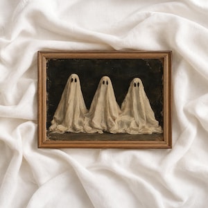May include: A rectangular framed wall art piece featuring a dark, textured background with three figures draped in off-white, translucent fabric sheets. Each figure has two distinct, dark, oval-shaped eye holes, creating a ghostly appearance.