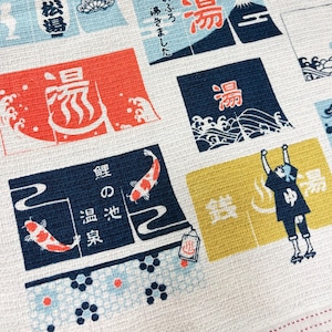 May include: A white fabric featuring a repeating grid pattern of rectangular blocks in red, blue, yellow, and light blue. Each block contains Japanese kanji characters, illustrations of Mount Fuji, koi fish, waves, and a person with arms raised.