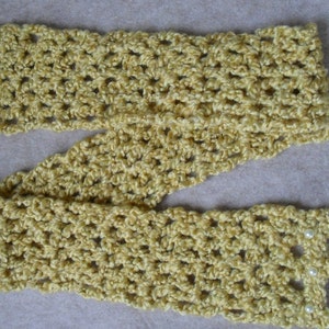 May include: A crocheted scarf in a light yellow color with white pearl accents. The scarf is made with a simple stitch pattern and has a delicate, feminine look.