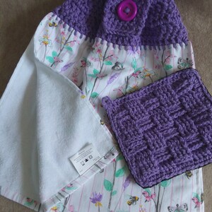 May include: Purple crocheted dish towels with a floral print and a purple button. The towels are made of cotton and are machine washable.