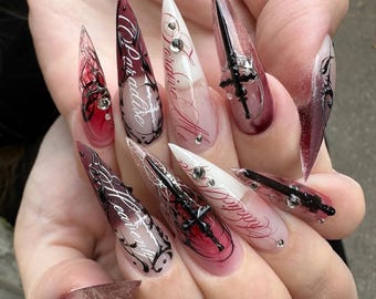 Unghie finte a stiletto gotiche, con motivo a croce rosso scuro e nera, set acrilico grintoso.