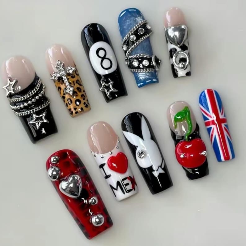 K&ouml;nnte beinhalten: Eine Sammlung k&uuml;nstlicher Fingern&auml;gel mit verschiedenen Designs. Enth&auml;lt N&auml;gel mit Sternen, Kreuzen, Leopardenmuster, der Zahl 8, Denim, Herzen, einem Hasen, einer Kirsche und einer britischen Flagge. Farben: Schwarz, Wei&szlig;, Rot, Blau und Beige.