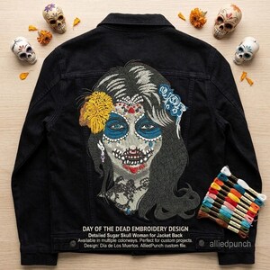 May include: A black denim jacket featuring a large, detailed embroidery of a woman with sugar skull makeup on the back. The design includes a yellow flower, blue roses, and intricate lace patterns. Text reads: DAY OF THE DEAD EMBROIDERY DESIGN.