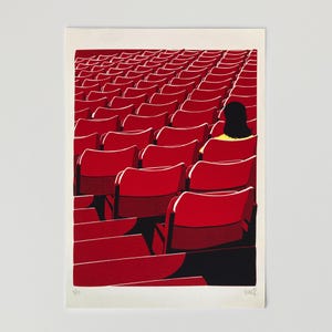 May include: A screen print illustration depicting a theater auditorium filled with rows of empty red seats. A single figure with dark hair wearing a yellow top sits in one of the seats. The artwork features a numbered edition and signature.