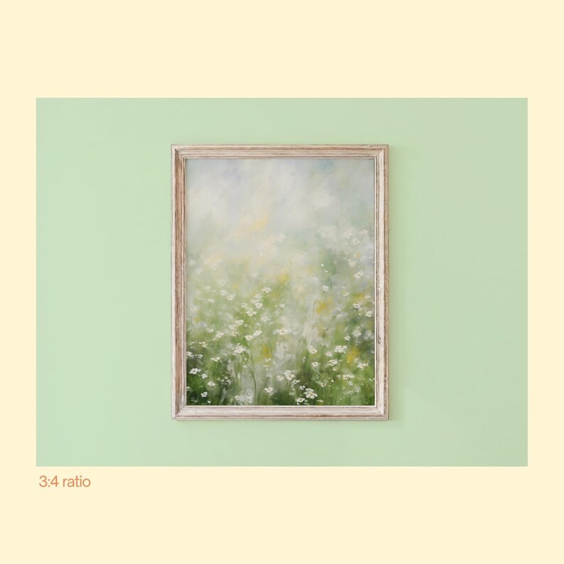 May include: A vertical rectangular wall art piece featuring an impressionistic oil painting of a field of small white wildflowers with soft green and yellow foliage, enclosed in a light-toned wooden frame with a visible grain texture.