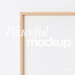 以下が含まれることがあります： 白い背景に、白い内装の明るい色の木製フレーム。 「Peaceful mockup」のテキストがエレガントな白いスクリプトで表示され、右下隅に番号「no.20」が表示されています。