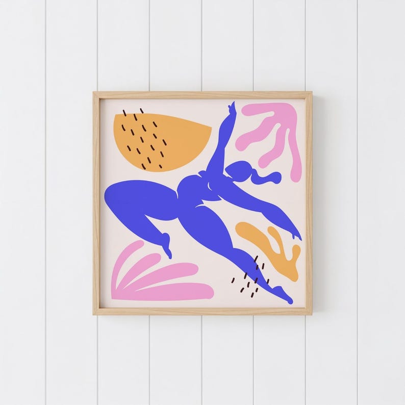 May include: A framed art print featuring a blue silhouette of a person in a dynamic pose, set against a cream background with abstract shapes in orange and pink. The artwork is enclosed in a natural wood frame.