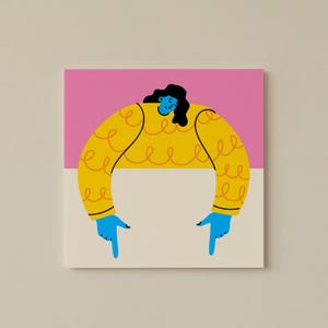 May include: A square art print featuring a stylized illustration of a person. The figure has blue skin, black hair, and is wearing a yellow sweater with a curly design. The background is divided into pink and beige sections, with blue hands pointing down.