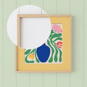 May include: A framed art print featuring a colorful floral design. The artwork includes a blue vase, pink and red flowers, and green leaves against a cream background, set within a yellow mat and a natural wood frame. The print is mounted on a light green wall.