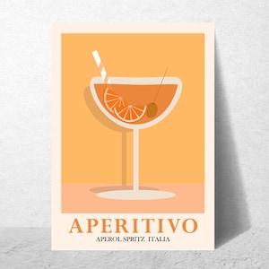 Op de afbeelding: Aperitivo-kunstprint met een gestileerde cocktail in een groot glas. De drank is oranje met een rietje, sinaasappelschijfje en olijf. De tekst "APERITIVO" en "APEROL SPRITZ ITALIA" is oranje op een crèmekleurige achtergrond.