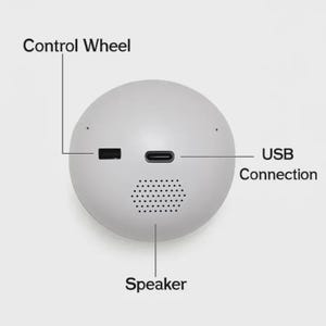 Puede incluir: Un dispositivo electr&oacute;nico esf&eacute;rico blanco con altavoz, conexi&oacute;n USB y rueda de control. El dispositivo tiene un dise&ntilde;o minimalista con las palabras "Control Wheel", "USB Connection" y "Speaker".