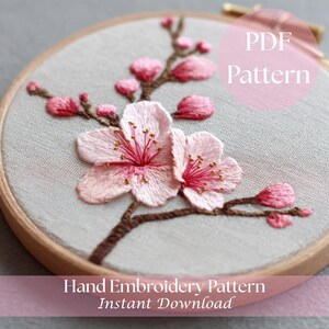 May include: Hand-embroidered floral pattern in a wooden hoop. The design features pink cherry blossoms with brown stems and the text "PDF Pattern" and "Hand Embroidery Pattern Instant Download".