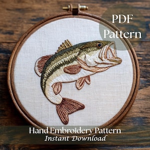 May include: An embroidered bass fish in a wooden hoop. The fish is detailed with shades of green, brown, and white, with its mouth open. The text "PDF Pattern" and "Hand Embroidery Pattern Instant Download" are visible.